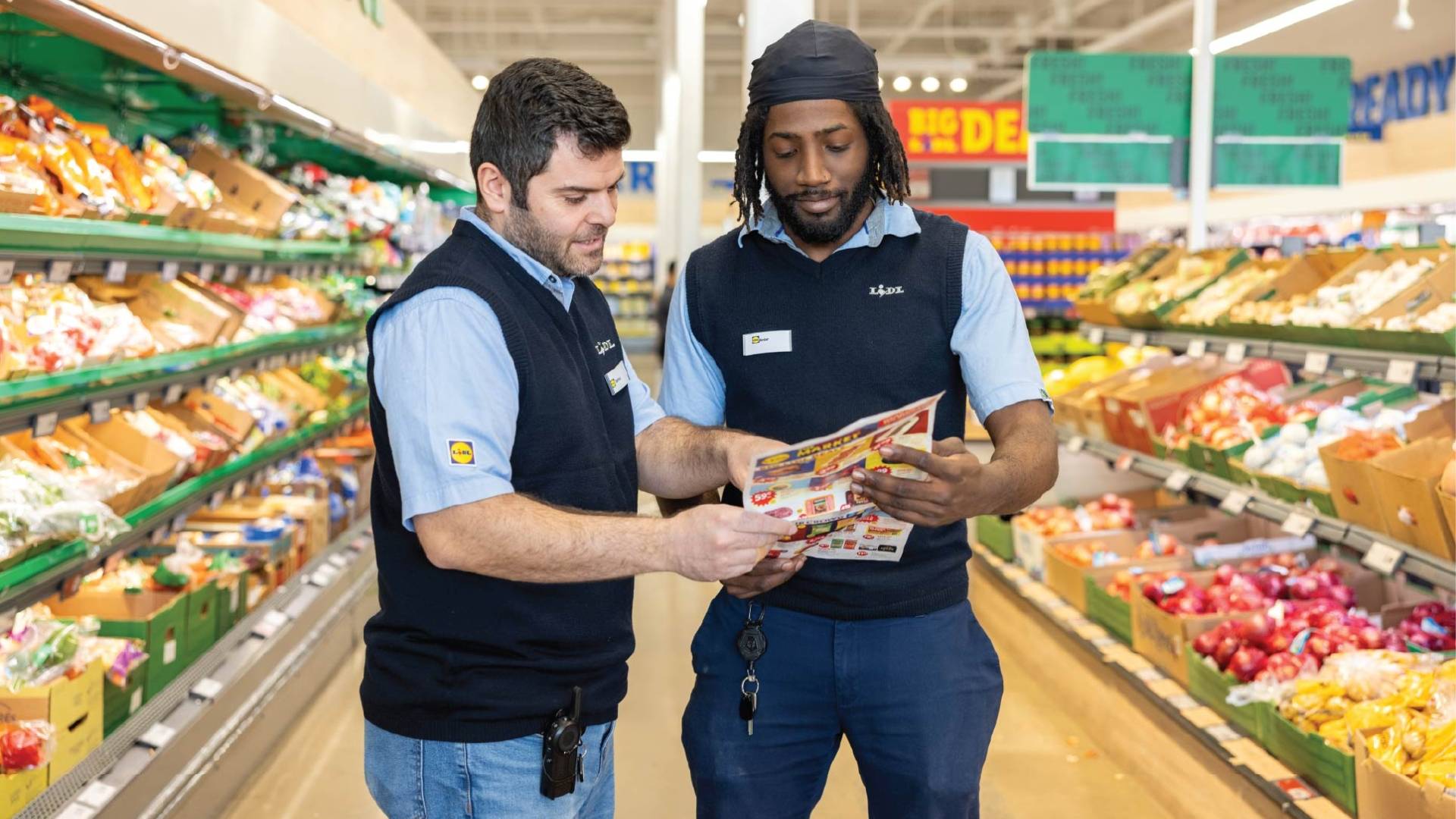 2 Men in Store Reviewing Pamphlet